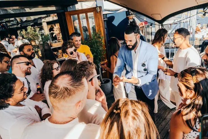 Kariem goochelt voor een groep gasten op een bootfeest