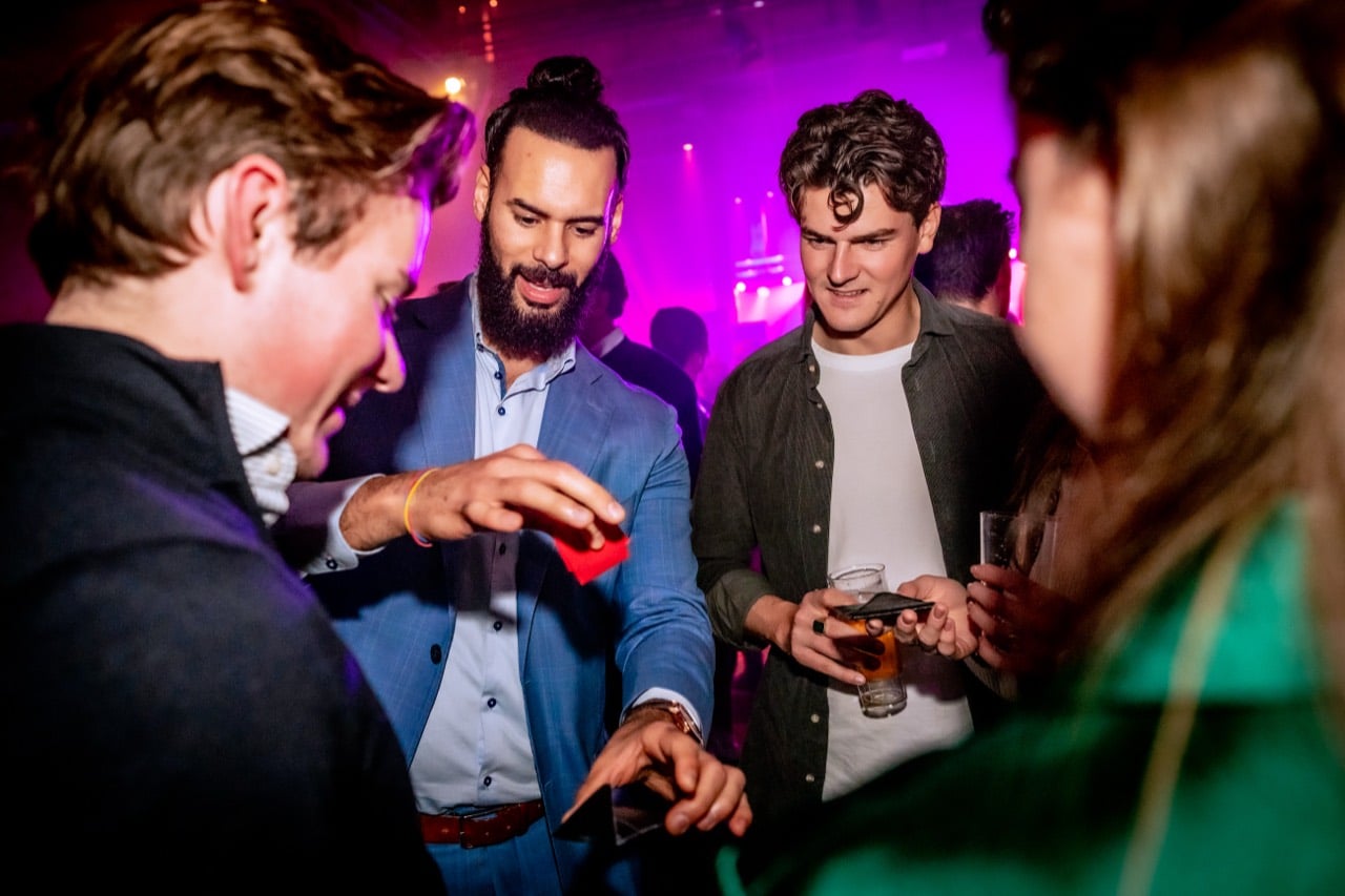 Kariem goochelt van dichtbij voor gasten op een bedrijfsfeest