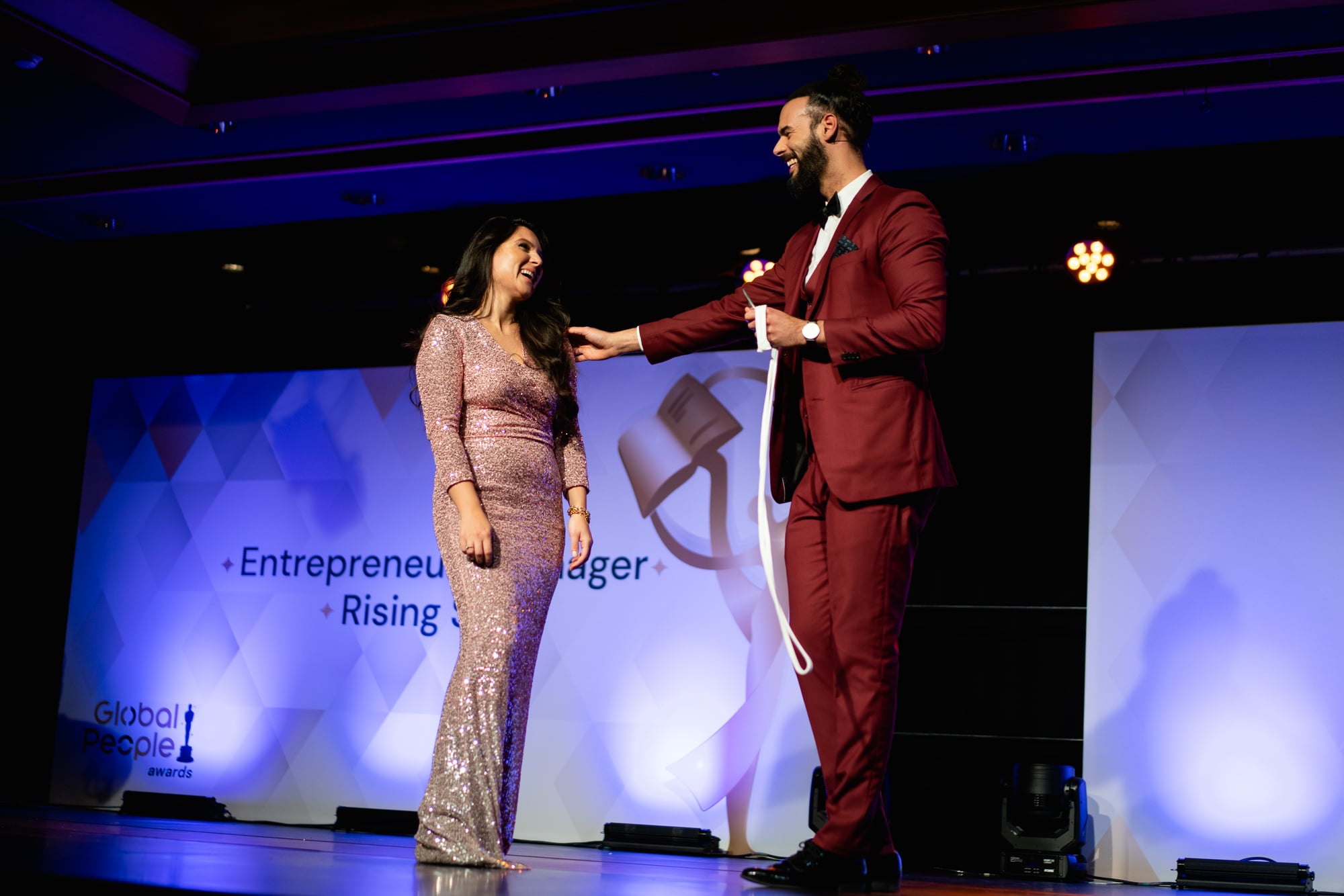 Kariem performing on stage with a guest at a corporate gala